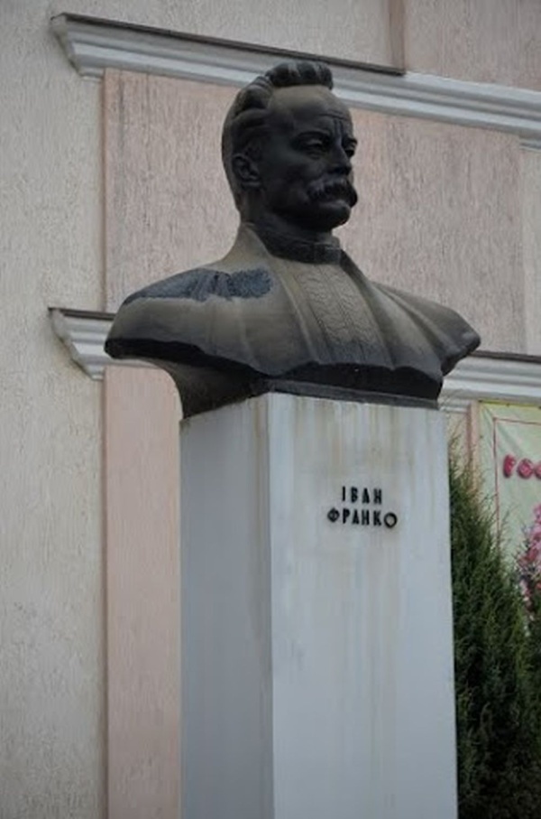 Rohatyn, pomnik Iwana Franki na tle dawnego chederu